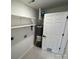 A utilitarian water heater on a tile floor with white shelving at 3735 Stonehaven Dr, Charlotte, NC 28215