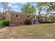 The back of the brick home features access to outdoor utilities and a partial view of the backyard at 3987 Taxahaw Rd, Lancaster, SC 29720