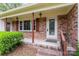 Inviting front porch with brick detailing, shutters and manicured landscaping at 3987 Taxahaw Rd, Lancaster, SC 29720