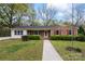 Charming brick home featuring mature trees, manicured shrubs, and a welcoming walkway at 3987 Taxahaw Rd, Lancaster, SC 29720