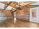 Open living room boasts brick walls, wood floors, and beamed ceilings at 3987 Taxahaw Rd, Lancaster, SC 29720