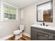 Bathroom features wood grain floors, gray vanity, and window for natural light at 5316 Teakwood Dr, Kannapolis, NC 28083