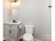 Bathroom features wood grain floors, a gray vanity, and modern fixtures at 5316 Teakwood Dr, Kannapolis, NC 28083