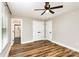 Bedroom features a ceiling fan, wood grain floors, and view into Primary bathroom at 5316 Teakwood Dr, Kannapolis, NC 28083
