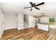 Open-concept living space with wood-look floors connecting the living room, stairs, and modern kitchen at 5316 Teakwood Dr, Kannapolis, NC 28083