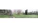 Expansive backyard with lush green grass, mature trees, and the home in the distance at 613 E 5Th St, Spencer, NC 29159