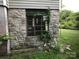 Stone basement exterior with a window covered in vines, providing a unique rustic charm at 613 E 5Th St, Spencer, NC 29159