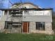 Two-story home undergoing renovation with stone foundation, scaffolding, and updated windows at 613 E 5Th St, Spencer, NC 29159