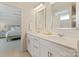 This bathroom offers double sinks with white cabinets and quartz countertop and is located next to the main bedroom at 7116 Brookline Pl, Huntersville, NC 28078