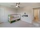 This bedroom has a twin bed with green trim and a ceiling fan; it also has a door to the hallway at 7116 Brookline Pl, Huntersville, NC 28078