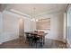 Elegant dining room featuring wood floors, wainscoting, a modern chandelier, and a decorative wall tapestry at 7116 Brookline Pl, Huntersville, NC 28078