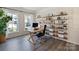 Bright home office featuring two windows, hardwood floors, and built-in shelving for storage and display at 7116 Brookline Pl, Huntersville, NC 28078