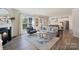 Cozy living room with a fireplace, natural light, and an open floor plan to the kitchen and dining areas at 7116 Brookline Pl, Huntersville, NC 28078