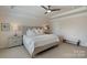 This main bedroom offers a tray ceiling, neutral colors and carpet, ceiling fan, and a luxurious upholstered headboard at 7116 Brookline Pl, Huntersville, NC 28078