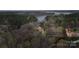 Aerial view of a home nestled among lush trees with a glimpse of the lake in the background at 8915 Linden Grove Ct, Sherrills Ford, NC 28673