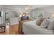 Bright bedroom featuring hardwood floors, a bed with neutral bedding, and a side desk, all well-lit by natural light at 8915 Linden Grove Ct, Sherrills Ford, NC 28673