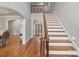 Spacious foyer showcasing hardwood floors, white stairs, iron railing, and views to dining and living areas at 8915 Linden Grove Ct, Sherrills Ford, NC 28673