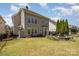 Spacious backyard with green grass, stone firepit with seating, and partial fencing at 9422 Ridgeforest Dr, Charlotte, NC 28277