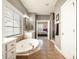 Beautiful primary bathroom showcasing a soaking tub, walk-in shower, and vanity with ample natural light at 9422 Ridgeforest Dr, Charlotte, NC 28277