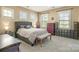 Inviting bedroom features a tufted headboard, bench, neutral color palette and plenty of natural light at 9422 Ridgeforest Dr, Charlotte, NC 28277