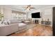 Cozy living room featuring a large sectional, fireplace and bright light from large windows at 9422 Ridgeforest Dr, Charlotte, NC 28277