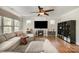 Open living room with large sectional, fireplace, ceiling fan, and shelves for storage at 9422 Ridgeforest Dr, Charlotte, NC 28277