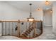 Elegant staircase with wood railings, iron spindles, and decorative lighting fixtures at 9422 Ridgeforest Dr, Charlotte, NC 28277