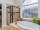 Elegant bathroom showcasing a standalone tub, a glass-enclosed shower, and a large window at 1009 Summer Creste Dr, Indian Trail, NC 28079