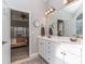 Well-lit bathroom featuring double sinks, a large mirror, and an open doorway to the bedroom at 1009 Summer Creste Dr, Indian Trail, NC 28079