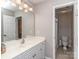 Bright bathroom with a white vanity, sink, and a well-lit mirror, adjacent to an enclosed toilet at 1009 Summer Creste Dr, Indian Trail, NC 28079