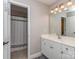 Well-lit bathroom features a white vanity, a large mirror, and a shower with a decorative curtain at 1009 Summer Creste Dr, Indian Trail, NC 28079