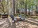 An outdoor patio area with comfortable seating surrounded by a serene, wooded landscape at 1009 Summer Creste Dr, Indian Trail, NC 28079