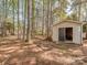 Backyard shed with an open door, providing ample storage space in a wooded setting at 1009 Summer Creste Dr, Indian Trail, NC 28079