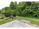The backyard showcases a concrete patio with brick trim and landscaping that includes shrubs and abundant trees at 10125 Loch Lomond Dr, Charlotte, NC 28278