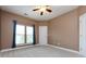 Bedroom with neutral colors, large window with curtains, and ceiling fan at 10125 Loch Lomond Dr, Charlotte, NC 28278