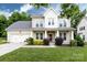 Charming two-story home with a well-maintained lawn, a two car garage, and lovely landscaping at 10125 Loch Lomond Dr, Charlotte, NC 28278