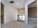 Upstairs hallway with carpet, railing overlooking foyer and entry to two separate bedrooms at 10125 Loch Lomond Dr, Charlotte, NC 28278