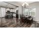 Modern dining area with dark wood floors, a stylish table, and a view into the kitchen at 1090 River Haven Sw Ave # 61, Concord, NC 28025