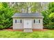 Outdoor storage shed with double doors and shutters in a green backyard surrounded by trees at 111 Sterling Dr, York, SC 29745