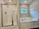 Bright bathroom features a walk-in shower, soaking tub, wood flooring, and window at 12815 Towering Pine Dr, Charlotte, NC 28269