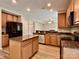 A well-lit kitchen featuring granite countertops, wood cabinets, stainless appliances, and a kitchen island at 12815 Towering Pine Dr, Charlotte, NC 28269