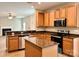 A well-lit kitchen featuring granite countertops, wood cabinets, stainless appliances, and a kitchen island at 12815 Towering Pine Dr, Charlotte, NC 28269