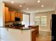 Well-lit kitchen with granite countertops, wood cabinets, stainless appliances, and an island at 12815 Towering Pine Dr, Charlotte, NC 28269