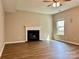 Cozy living room with a fireplace, modern flooring, and a ceiling fan for a comfortable and inviting atmosphere at 12815 Towering Pine Dr, Charlotte, NC 28269