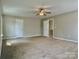 Expansive bedroom with neutral paint, ceiling fan, carpet, and convenient access to ensuite bathroom at 12815 Towering Pine Dr, Charlotte, NC 28269
