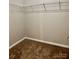 Neutral walk-in closet with metal shelving and carpet flooring ready for organizing at 12815 Towering Pine Dr, Charlotte, NC 28269