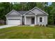 Charming single-story home boasts a manicured lawn, attached garage and a welcoming entrance at 1721 Balfour Ln, Charlotte, NC 28216