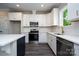 Modern kitchen features white cabinets, stainless steel appliances, and a stylish island with quartz countertops at 1721 Balfour Ln, Charlotte, NC 28216