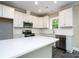 Modern kitchen features white cabinets, stainless steel appliances, and a stylish island with quartz countertops at 1721 Balfour Ln, Charlotte, NC 28216