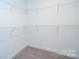 Walk-in closet with white wire shelving ready for optimal storage at 1721 Balfour Ln, Charlotte, NC 28216